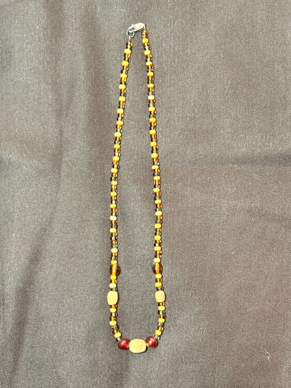 Beaded necklace featuring amber-toned and dark beads.